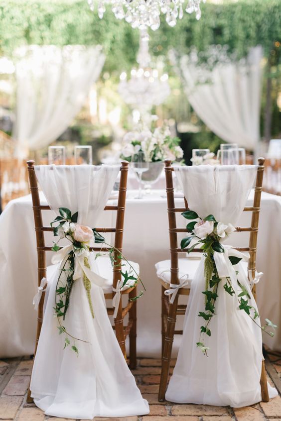 Cute white wedding chairs for the bride and groom